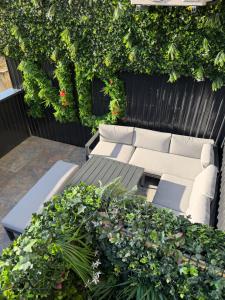 a patio with a couch and a bunch of plants at Nuit D Or LoveRoom in Bellegarde-sur-Valserine