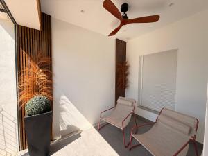 a room with two chairs and a ceiling fan at ALGAIDAMAR BEACH LUXURy in Sitio de Calahonda