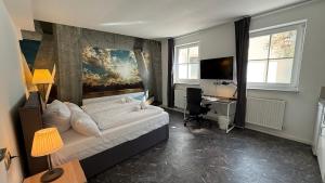 ein Schlafzimmer mit Bett, Schreibtisch und Fernseher in der Unterkunft Kastanienbaum in Herzogenaurach