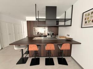 a kitchen with a island with a sink and stools at ALGAIDAMAR BEACH LUXURy in Sitio de Calahonda