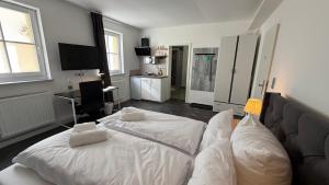 ein Schlafzimmer mit einem weißen Bett und einem Sofa in der Unterkunft Kastanienbaum in Herzogenaurach