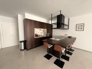 a dining room with a dark wooden table and chairs at ALGAIDAMAR BEACH LUXURy in Sitio de Calahonda