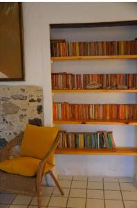 a room with a chair and a shelf of dvds at Ocean front surf House El Cotillo in El Cotillo