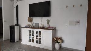 a white cabinet with a flat screen tv on a wall at Domus de mare in Cala Gonone +28 photos