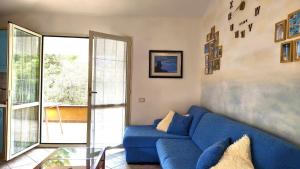 a living room with a blue couch and a glass table at Domus de mare in Cala Gonone
