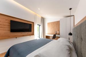 a bedroom with a bed and a flat screen tv at Villa Senzen in Baška Voda +22 photos