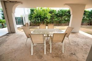 a table and chairs in a patio with trees at Spata sunrise house in Spata +52 photos