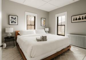 a large white bed in a bedroom with two windows at The Yarra in Roscoe