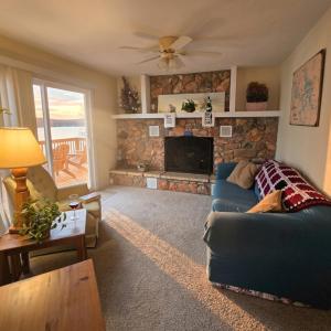a living room with a blue couch and a stone fireplace at Markley Manor - Beautiful views in Sunrise Beach