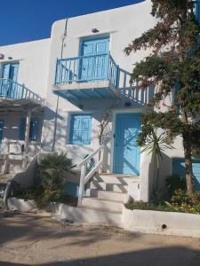 a white building with a blue door and stairs at Mykonos efis maisonette in Mikonos