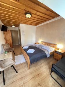 a bedroom with a large bed and a wooden ceiling at Slanický Dvor in Námestovo
