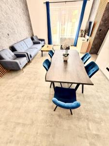 a living room with a wooden table and blue chairs at Teplice Apartments 1 in Teplice +8 photos