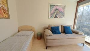 a living room with a couch and a window at Panoramic Art Apartment with jacuzzi in Balatonlelle