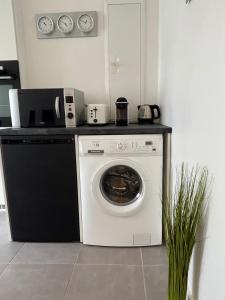 a washing machine in a kitchen with a counter at Centre ville - Le Creusot in Le Creusot +11 photos