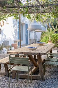 a wooden picnic table with chairs and a pendant light at Luxury family villa with large pool, garden & outdoor dining near beach, Domaine l'Oiseau Bleu in Sainte-Maxime in Sainte-Maxime