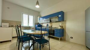 a kitchen with blue cabinets and a table and chairs at Appartamento Le Crugnole in Montepulciano