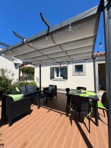 a patio with awning and a table and chairs at Beach House Largo da Agrela in Viana do Castelo
