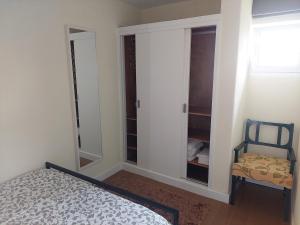 a bedroom with a bed and a chair and a closet at Beach House Largo da Agrela in Viana do Castelo