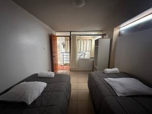 a bedroom with two beds and a door to a balcony at Domi ApartHotel , first floor and duplex in Cusco