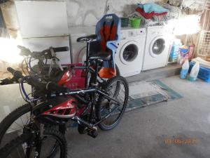 two bikes parked in a laundry room with a washing machine at Beach House Largo da Agrela in Viana do Castelo