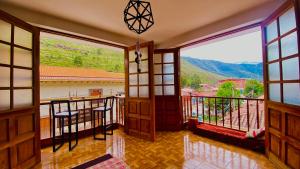 a room with a balcony with large windows at Aqui y Ahora in Pisac