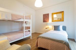 a bedroom with two bunk beds and a couch at Espaço Calheta in Ponta Delgada