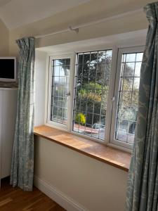 a window in a room with two windows with curtains at Otter's Reach in Budleigh Salterton