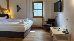 ein Hotelzimmer mit einem Bett und einem Stuhl in der Unterkunft Kastanienbaum in Herzogenaurach + 17 Fotos