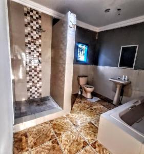 a bathroom with a toilet and a sink and a tub at Aquamarine Guesthouse in Morula Sun +22 photos