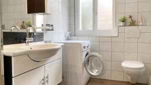 a white bathroom with a sink and a toilet at Apartment mit Balkon in Brienz +34 photos