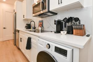 a kitchen with a washer and dryer on a counter at Chic 2BR Stay-Steps From Central Park in New York +13 photos