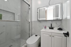 a bathroom with a toilet and a sink and a shower at Chic 2BR Stay-Steps From Central Park in New York
