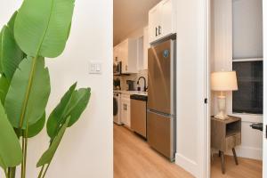 a kitchen with a refrigerator and a table with a lamp at Chic 2BR Stay-Steps From Central Park in New York