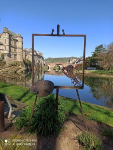 a painting on a stand next to a body of water at Le Puits Enchanté in Espalion