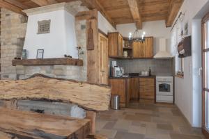 a kitchen with wooden cabinets and a stone wall at Hárs Vendégház in Balatonendréd +15 photos