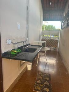 a bathroom with a sink and a mirror and a table at Suíte Refúgio das Suculentas Master Confort in Socorro