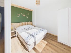 a small bedroom with a bed and a green wall at Les Roches d'Argent & Beg Douar in Plestin-les-Grèves