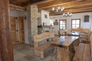 a kitchen with a wooden table and a stone fireplace at Hárs Vendégház in Balatonendréd