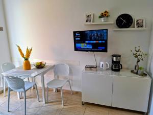 a dining room with a table and a tv on a wall at Apartamento ELIDE in Costa Del Silencio
