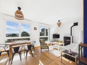 a living room with a table and chairs and a fireplace at Les Roches d'Argent & Beg Douar in Plestin-les-Grèves