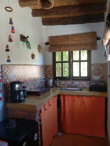 a kitchen with orange cabinets and a counter with a microwave at Los Amarantos in Tilcara +41 photos