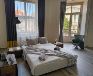 a bedroom with a large bed with towels on it at City Art Inn in Szeged