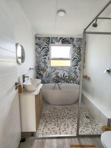 a bathroom with a tub and a sink and a shower at Ocean Whisper Beach Villas in Jeffreys Bay +49 photos