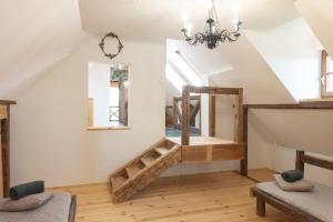 a living room with a staircase and a chandelier at Hárs Vendégház in Balatonendréd