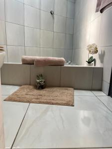 a bathroom with a bath tub and a rug at Mbizana Lifestyle in Monzi +6 photos