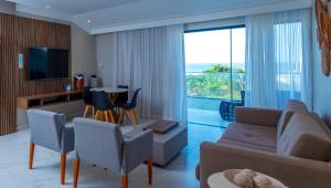 a living room with a couch and a table with chairs at Hotel Privê do Atalaia in Salinópolis