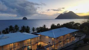 a resort with a view of the ocean and a mountain at Suite Caraïbe vue mer in Le Diamant