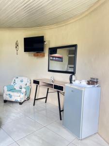 a room with a desk and a chair and a television at Mbizana Lifestyle in Monzi