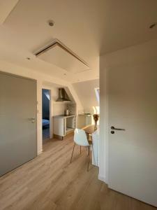 a room with a table and a chair and a desk at - Le 4ème Tourbillon- in Molsheim