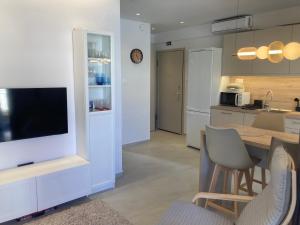 a kitchen with a table with chairs and a tv at La casa di Zoe in Flogita